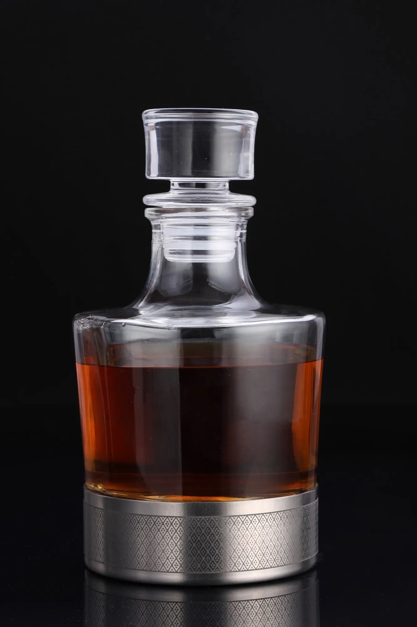 The decanter on its titanium base, filled with whiskey