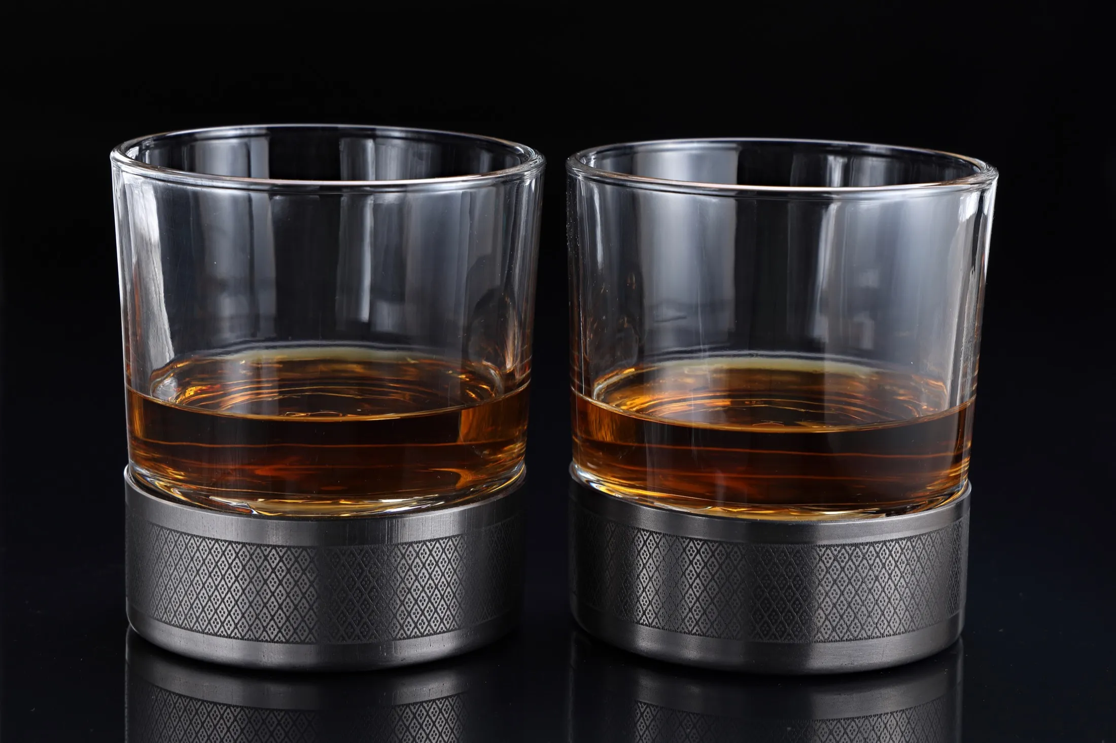 Two whiskey glasses side by side on titanium bases