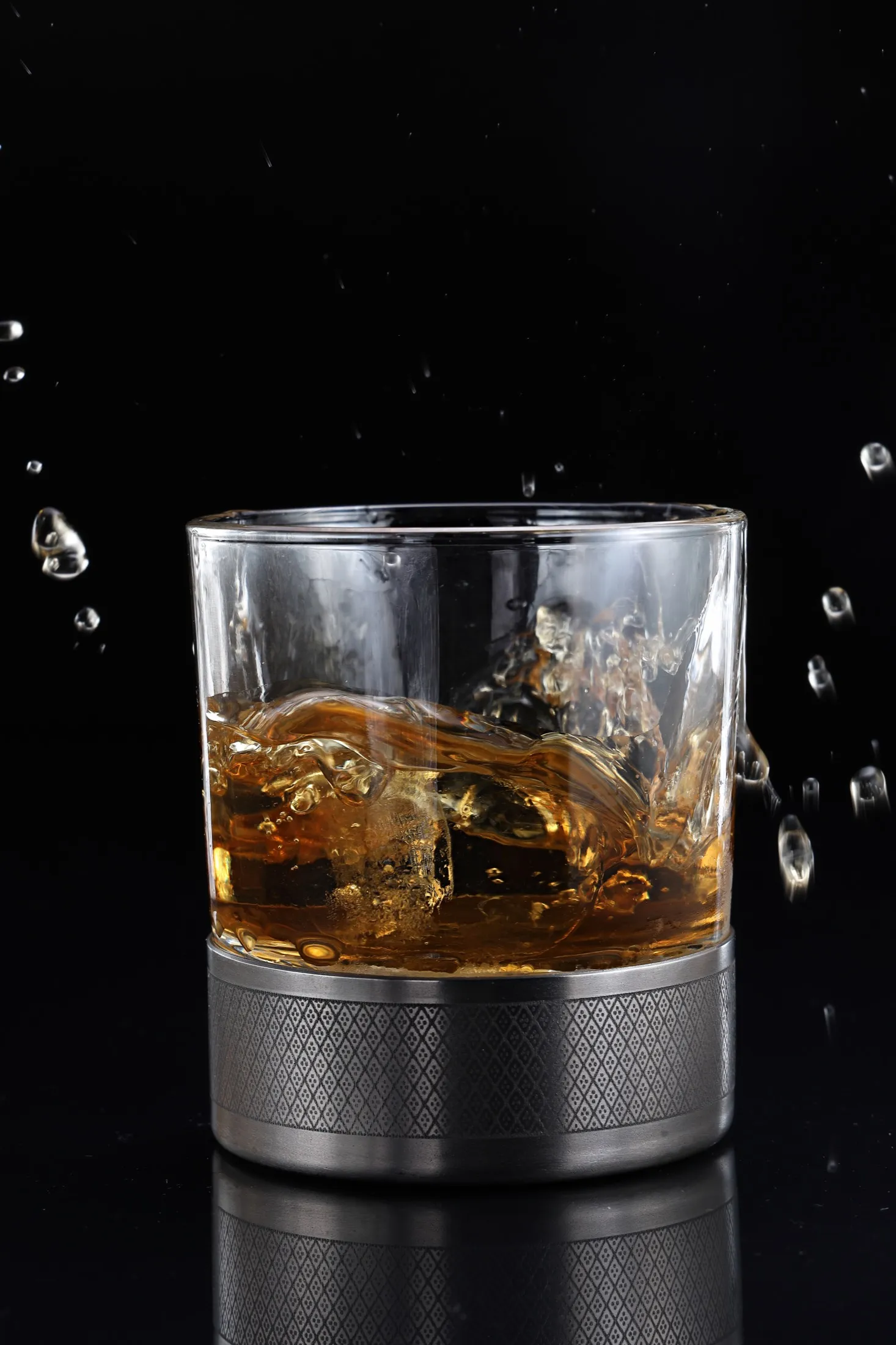 Whiskey splashing out of a glass on a titanium base